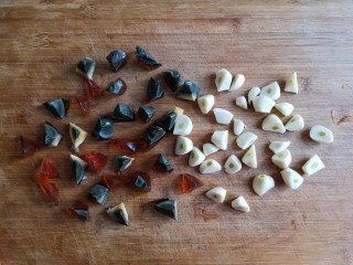 5、焦蒜皮蛋浸菠菜,将蒜瓣和皮蛋都切滚刀块。