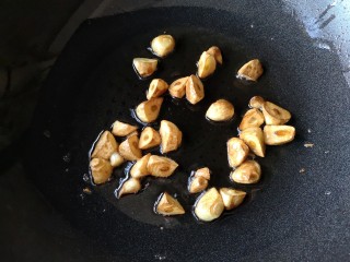 8、焦蒜皮蛋浸菠菜,煎至大蒜表面焦黄后沥油盛出备用。