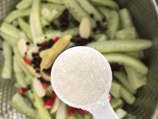 10、快手腌黄瓜～青脆爽口,把所有配料：花椒，八角，姜，蒜，辣椒都加入沥干水的黄瓜条里，加入一勺白糖，有冰糖更好