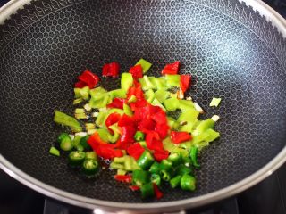 9、杭椒炒鹌鹑蛋,这个时候加入杭椒和青椒，红椒大火翻炒片刻。