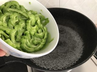 11、绿色美食~苦瓜炒蛋,锅里烧开水后,苦瓜倒入灼水,去除草酸,不要太久,变色即捞起