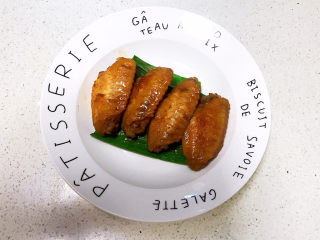 22、可乐鸡趐,先把香蒜叶放入盘底，再把烧好的可乐鸡翅夹出来