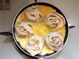 25、玫瑰花抱蛋煎饺,倒入平底锅里，盖上盖子，继续煎至蛋液完全凝固。