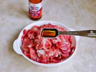 1、香菇炒肉片,首先将牛肉片洗干净，挤干水分装盘，加入料酒。