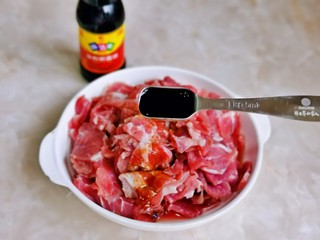 2、香菇炒肉片,加入1勺生抽。