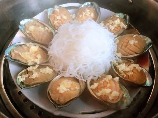 6、蒜蓉粉丝蒸鲍鱼,撒上适量蒜蓉放入开水蒸锅中大火蒸5分钟
