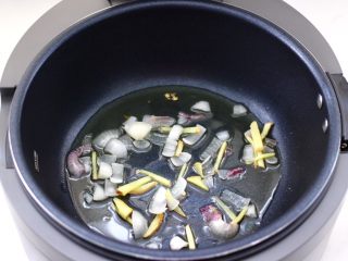 8、啤酒红烧小土豆鸡腿,智能炒菜机里先倒入花生油，洋葱碎和姜丝。