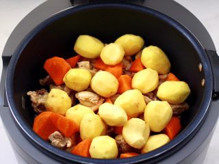 10、啤酒红烧小土豆鸡腿,再倒入小土豆和胡萝卜块。