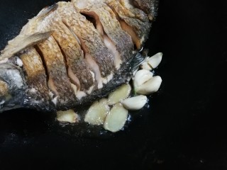 5、白酒香菜鳊鱼,放入蒜瓣姜片