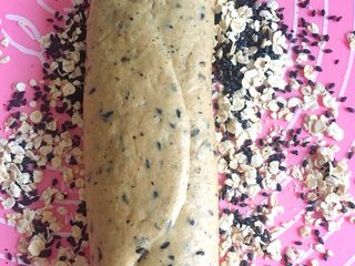 11、三麦低脂代餐健康吐司,将醒好的一卷收口朝上,放在燕麦和黑芝麻的混合物上。