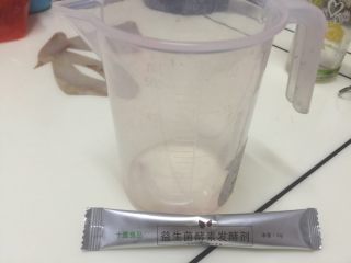 4、水果酵素(玫瑰花陈酿酵素),激活菌粉，在量杯中加入100ml温水，倒入菌粉搅拌溶解待用