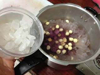 6、紫薯莲子银耳羹,放入莲子和紫薯块,按口味加入冰糖。再次盖上,大火煮至喷气转中小火再继续15分钟。