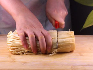 2、往青椒里塞入半斤金针菇，这味道绝了！,首先将所有食材准备后我们先来处理金针菇，用刀子将金针菇的根部切掉。