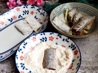 5、茄汁带鱼(罐头),取面粉一份放入盘中,如图裹面粉。