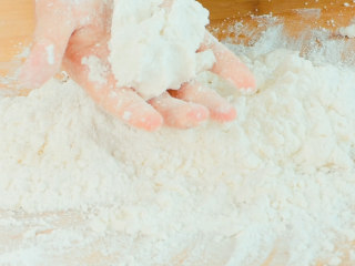 3、玫瑰云片糕,搅拌均匀，能手握成团不散就可以。水少量的加，不要一次加多了，糯米粉的吸水性会不一样，大家要根据自己粉的情况来加水。如果水加多了，就再放点糯米粉。