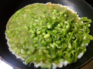 10、抱蛋青椒毛豆,倒入搅拌好的青椒毛豆鸡蛋。