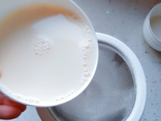 21、午后时光_红枣双皮奶,将混合好的牛奶从过滤网倒到有斜嘴的量杯里