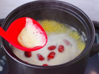 8、红薯百合红枣小米粥,用勺子撇去上面的浮末。