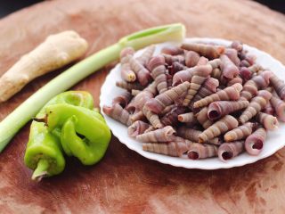 3、辣爆锥螺,把冲洗干净的锥螺放入盘子里,准备好其它材料。