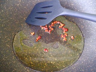 5、辣爆锥螺,锅烧热后,倒入花生油烧至六成熟时,炸香花椒。