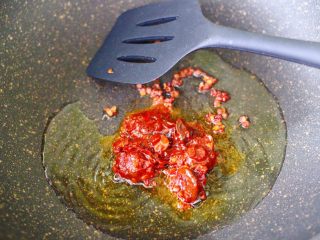 6、辣爆锥螺,再放入郫县豆瓣酱。