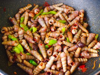 15、辣爆锥螺,大火翻炒至青椒断生变色的时候,即可关火。