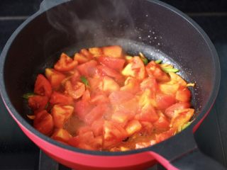 7、金针菇海兔汤,锅烧热倒入花生油,先爆香葱姜后,再倒入番茄块进行煸炒。