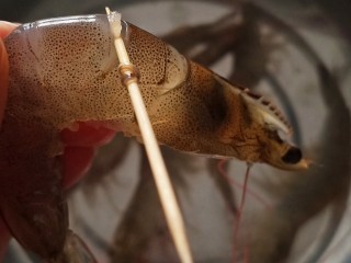 1、耳光炒饭,首先处理一下虾。用牙签在虾背第二个节戳进去，慢慢向上把虾线挑出来。虾脚虾须和头部都处理干净