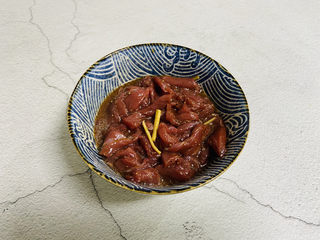 5、西兰花炒牛肉,牛肉放入碗中加入一勺生抽、料酒、适量的黑胡椒粉、白糖、鸡精、生粉、姜丝抓匀腌制十分钟