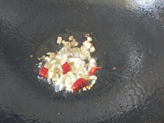 6、家常蒜苗炒丝瓜,放入姜蒜末和干辣椒段炒香