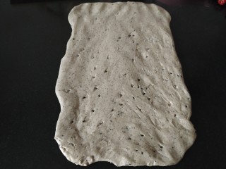 6、黑芝麻全麦核桃红枣软欧包~~安安原创,取一份面团用擀面杖擀成长方形或者长方形，如果擀的过程有回缩，就是没松弛好，可以继续松弛几分钟；