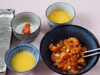 10、少油减脂的劲爆鸡米花,把食材调料分别装在不同的器具中，先把腌制好的鸡肉块放在玉米淀粉碗中，均匀裹上一层薄薄的淀粉。