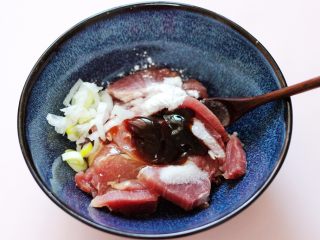 9、超爽的麻辣孜然烤肉串,所有的调料都加入以后，再把切丝的葱放到碗里面。