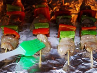 18、超爽的麻辣孜然烤肉串,烤制到10分钟的时候，把肉串从烤箱拿出来，再次把肉串刷上一次食用油，这样就可以锁住水分不流失。