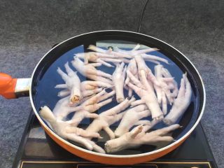 3、柠檬舂鸡脚,添加适量清水，泡好的鸡爪倒入锅中。