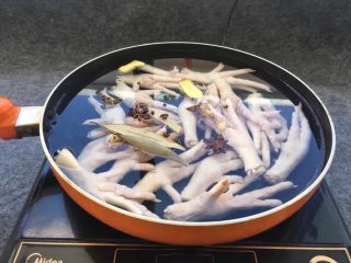 4、柠檬舂鸡脚,锅中添加老姜片、八角、桂皮、香叶、花椒。