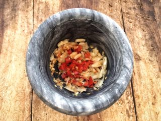 15、柠檬舂鸡脚,先将小米辣与大蒜舂碎。