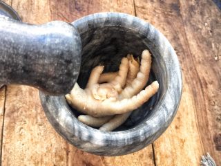 23、柠檬舂鸡脚,传统做柠檬舂鸡脚，把蒜瓣放入臼里，（一般使用的都是木臼有脸盆那么大，舂深有几十厘米高）放入几颗小米辣舂碎。然后放入豇豆舂碎，洋葱舂碎，最后放入鸡脚舂碎，不用太烂。再用挤压器挤出柠檬汁，挤到臼里，挤过的柠檬同样放入臼中。放入各种调料，盐，味精，柠檬汁，辣椒酱，芫荽（当地有两种，大小芫荽），胡萝卜丝，花生碎等调料。因为自己用的是小舂条件上有所限制，把舂好的调料舀放大盘中，再把冰镇的鸡脚放入舂中舂碎。