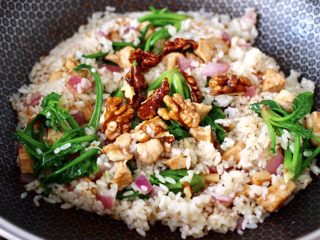 16、鸡丁核桃菠菜炒饭,大火翻炒均匀后，上面撒上炸香的核桃即可关火。