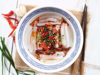 12、麻辣猪皮冻,将辅料里的材料,除了葱和生抽、耗油之外,其他全部下锅爆炒一下,炒出香味后淋在猪皮冻上,然后将生抽和耗油简单混合后也淋在上面,最后撒上葱花即可