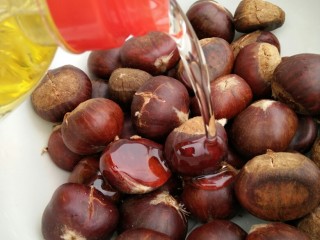 5、黑乐砂锅烤板栗,把切好的板栗放到碗里，放一大勺植物油