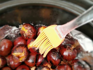 9、黑乐砂锅烤板栗,烤了15分钟后，用刷子沾上糖水刷到每个板栗上，最好是刷在板栗的裂口处