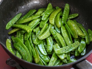 8、荷兰豆炒肉,就锅中底油放入荷兰豆大火快速翻炒一、两分钟