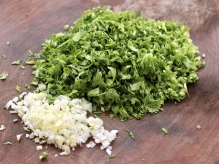 2、冬至美食~牛肉茼蒿饺子,茼蒿摘洗干净后切碎,大葱也切碎。