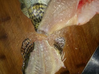 3、鸿运松鼠桂鱼,3.斩去龙骨,将胸部大刺片去,鱼肉打人字花刀,由于鱼肉有点透明,我厨房灯光暗,改刀看不清楚!拍淀粉时候可以看见!