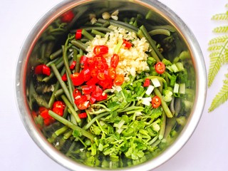 6、鲜嫩可口的凉拌蕨菜,倒入准备好的配料。