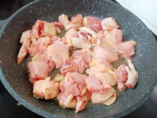 3、黄焖鸡块,锅中入油下大蒜、姜片煸炒、大火时加鸡块下锅快速煸炒。