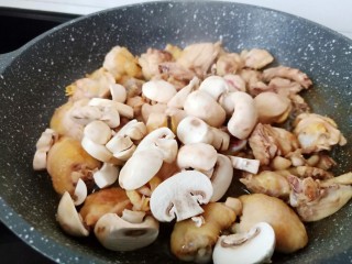 5、黄焖鸡块,加入蘑菇翻炒均匀。