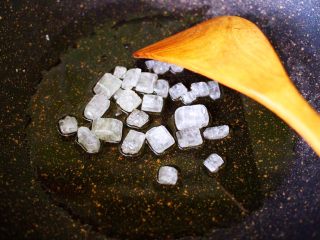 7、红烧牛肉炖大蒜,锅中烧热倒入花生油，放入冰糖小火慢慢炒至融化变成黄色。