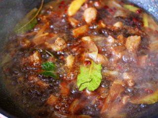 14、红烧牛肉炖大蒜,加入香叶，大火继续煮沸。